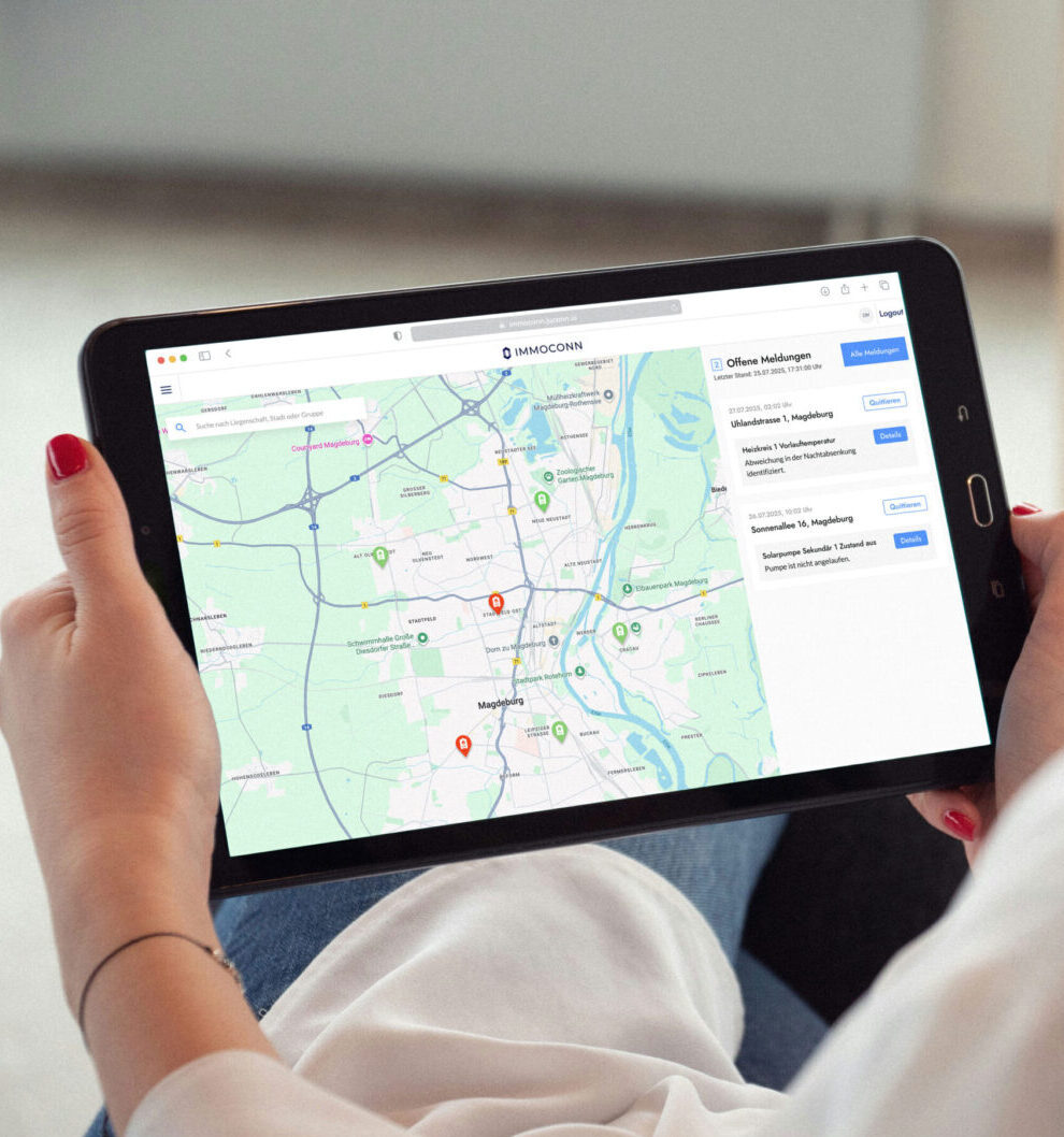 Frau hält ein Tablet in den Händen, auf dem eine Karte mit Markierungen und der Weboberfläche von IMMOCONN angezeigt wird.